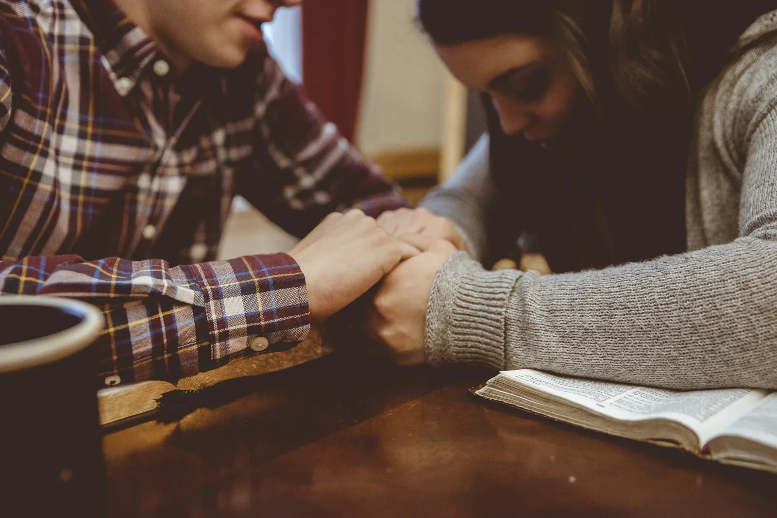 A couple praying together over a Bible