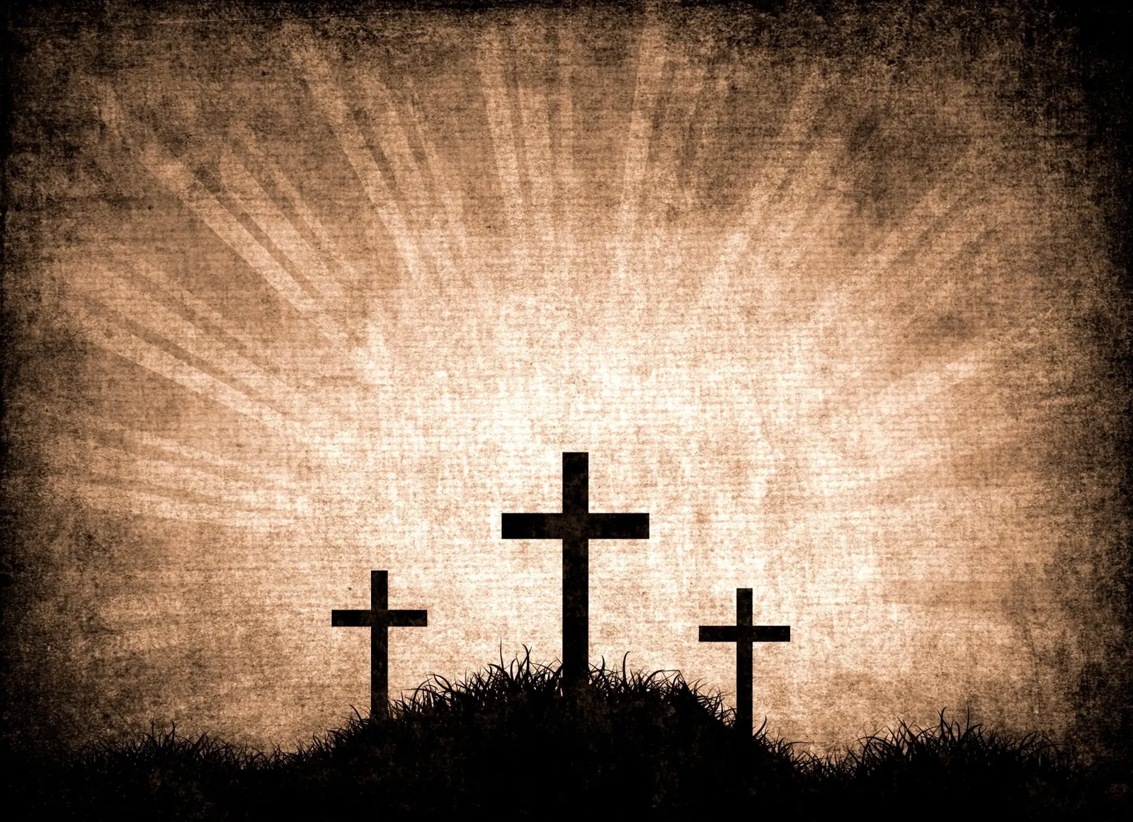 Three crosses on a hill against a radiant sky